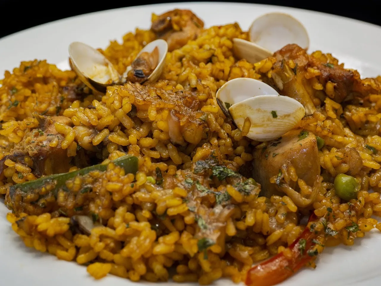 A paella-style rice dish with clams and chicken