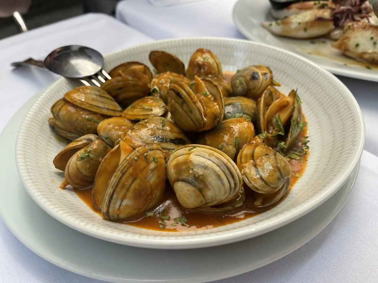 A bowl of clams in a garlicky broth