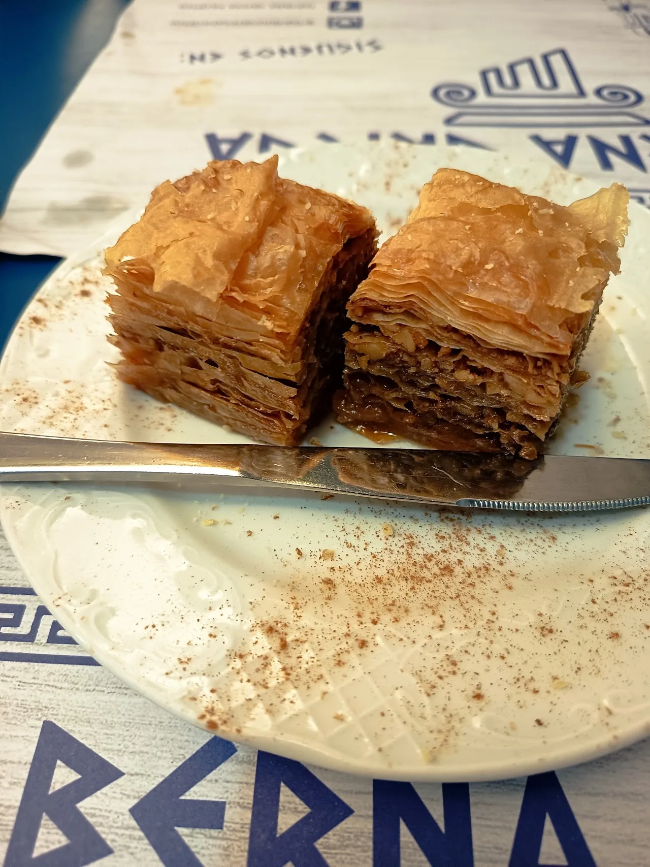 Two golden squares of baklava dusted with cinnamon