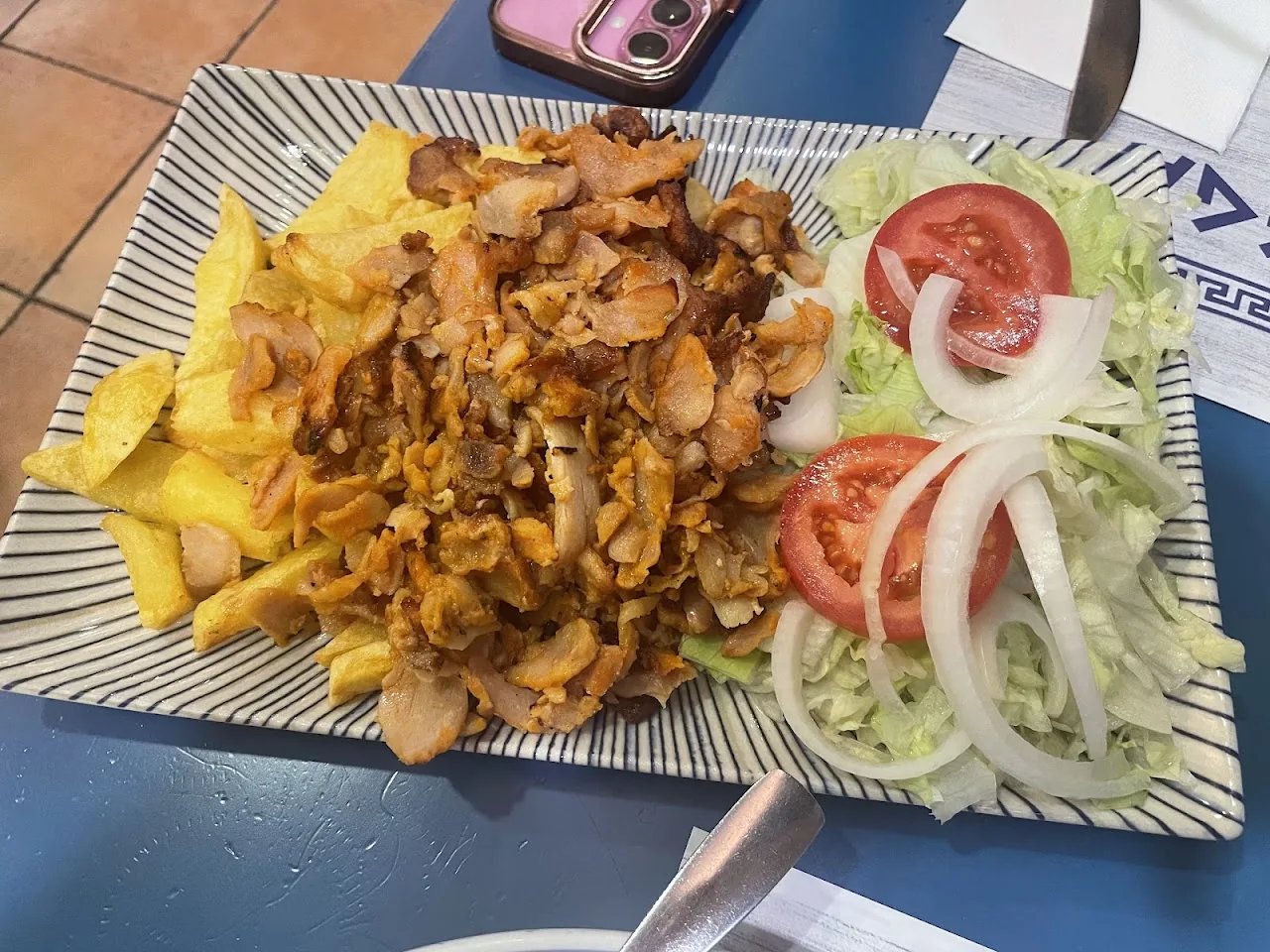 A gyro platter with pita, fries, tomato, and onion