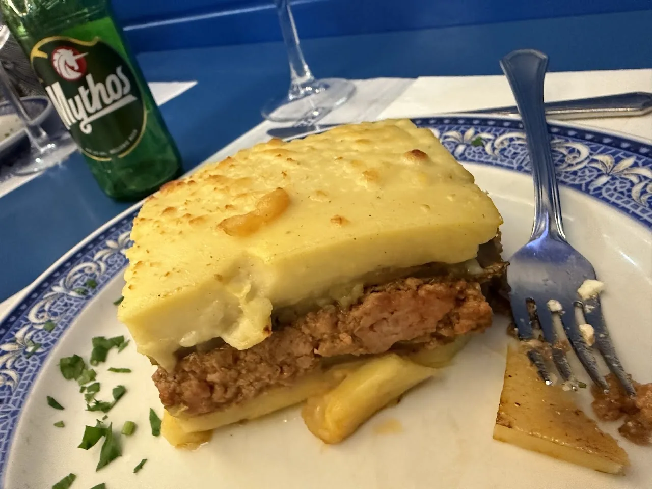A slice of moussaka on a plate with a fork