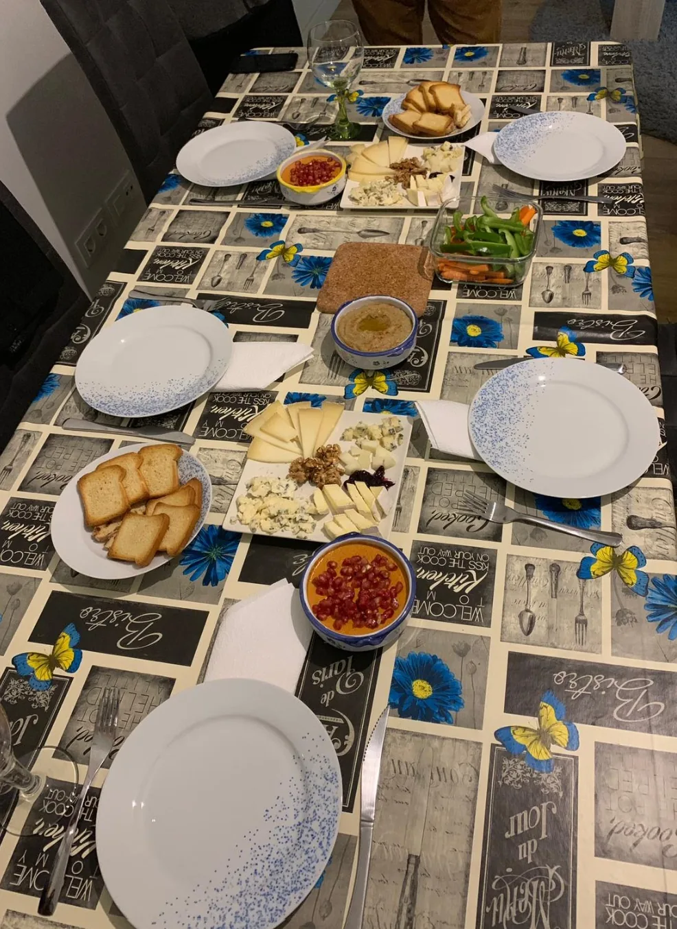 A table spread of small appetizer plates including bread, dips, and cured meats