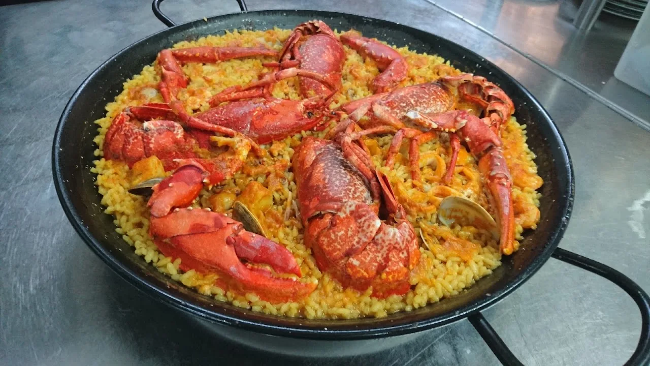 A pan of paella topped with whole langoustines and crab