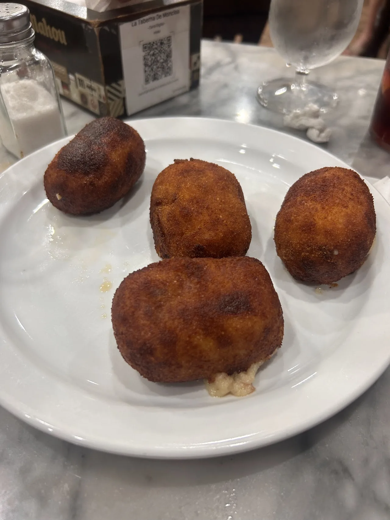 Four golden fried croquettes on a plate
