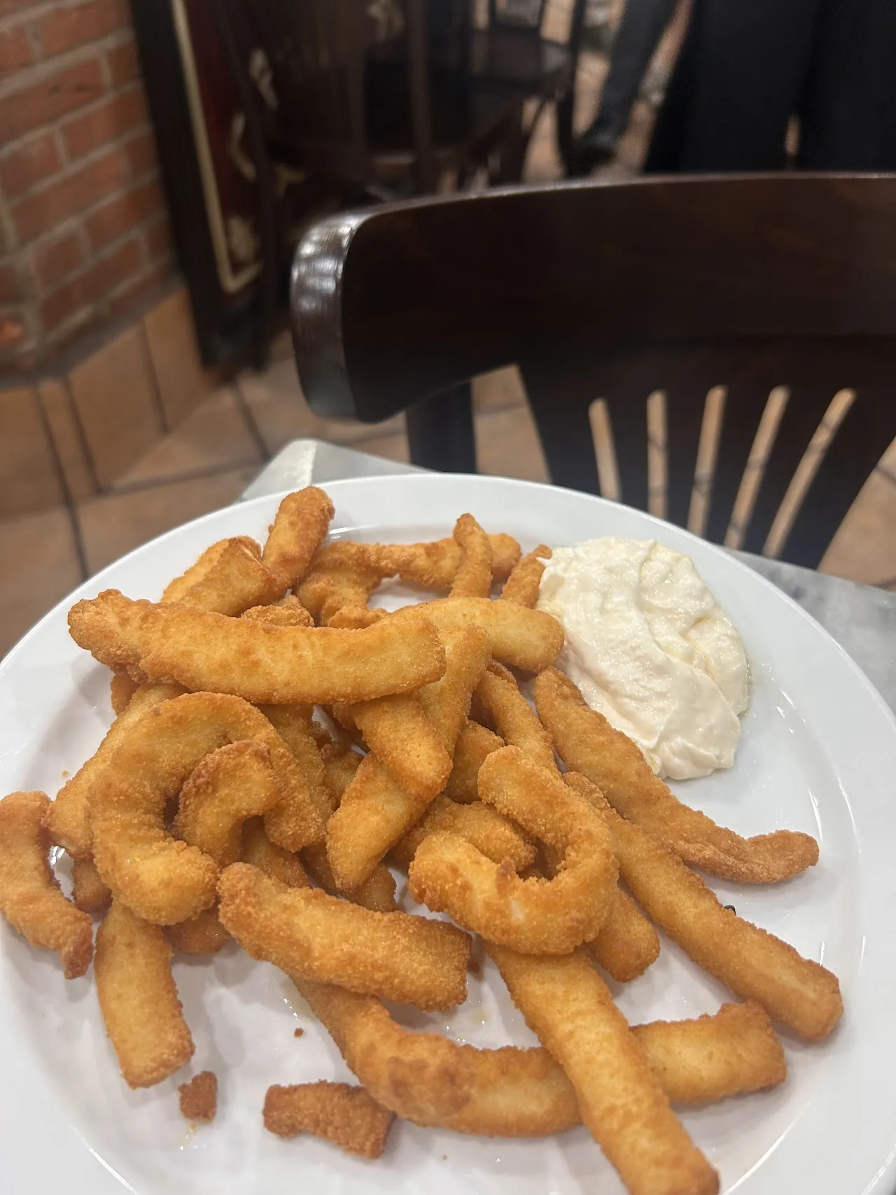 A plate of churros with a dipping sauce