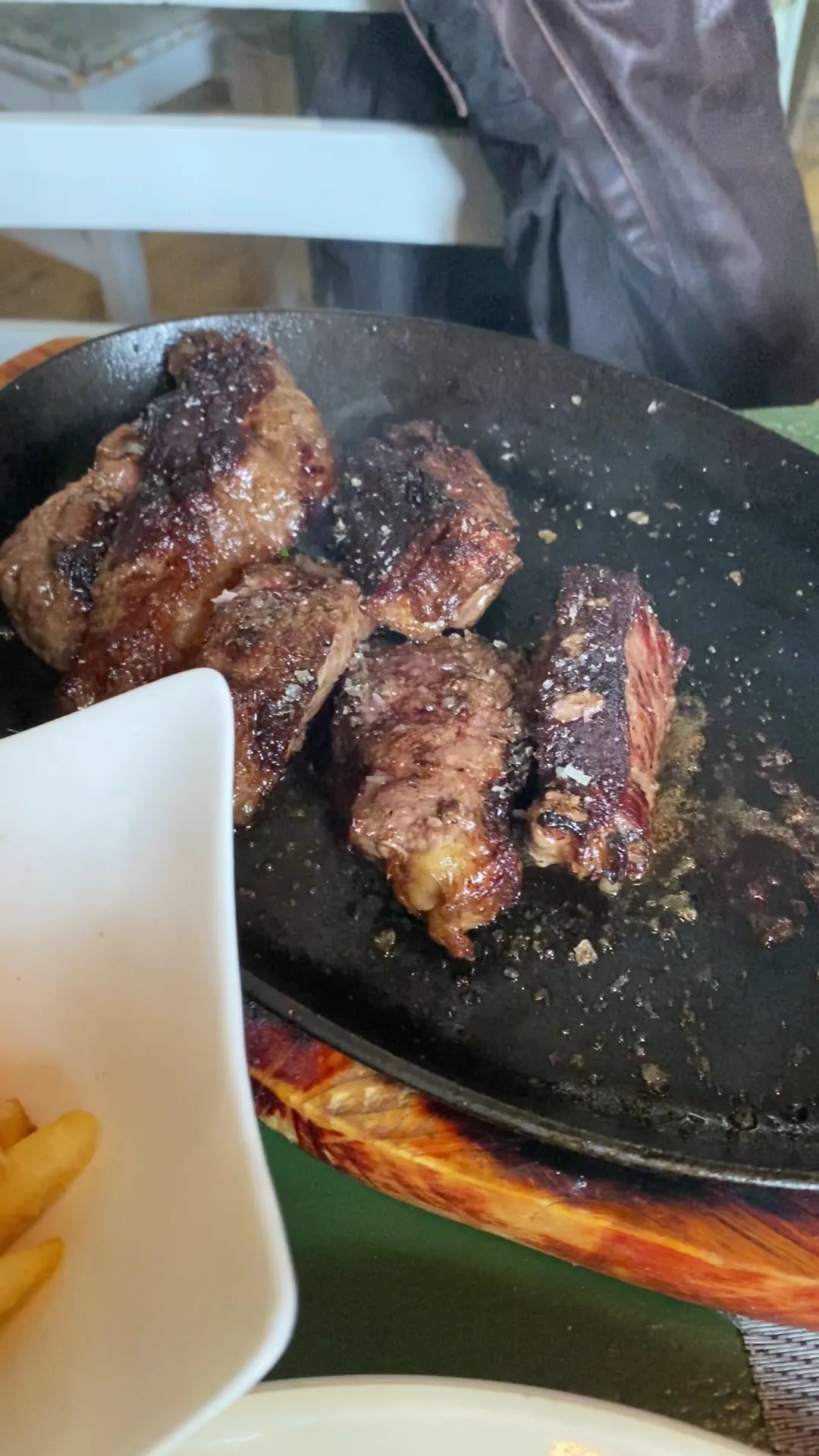 Grilled pieces of meat with a side of fries