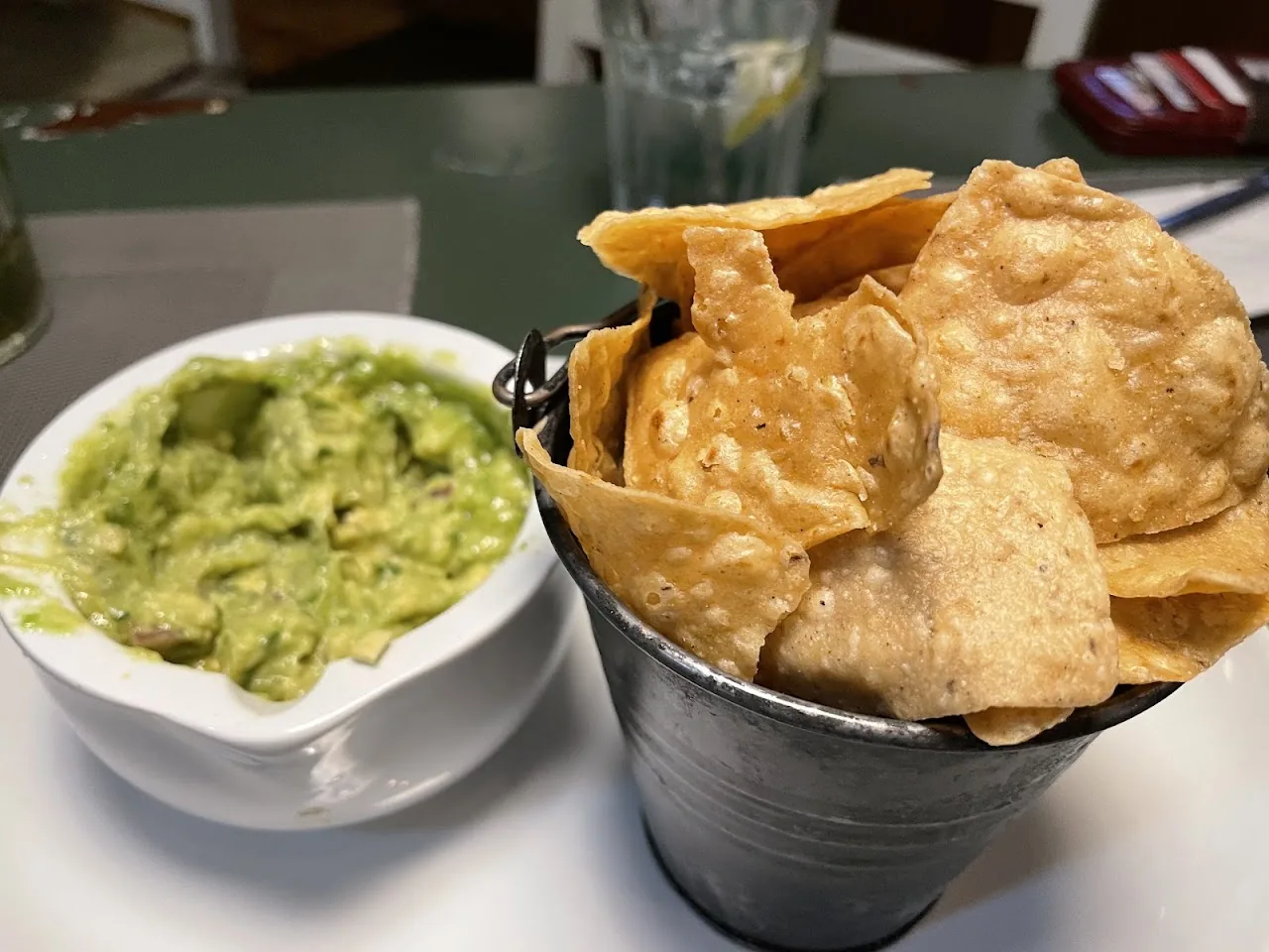 Guacamole served with tortilla chips in a small bucket