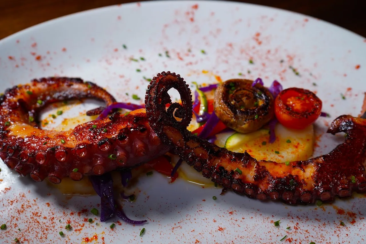 Grilled octopus slices with paprika and a red pepper sauce