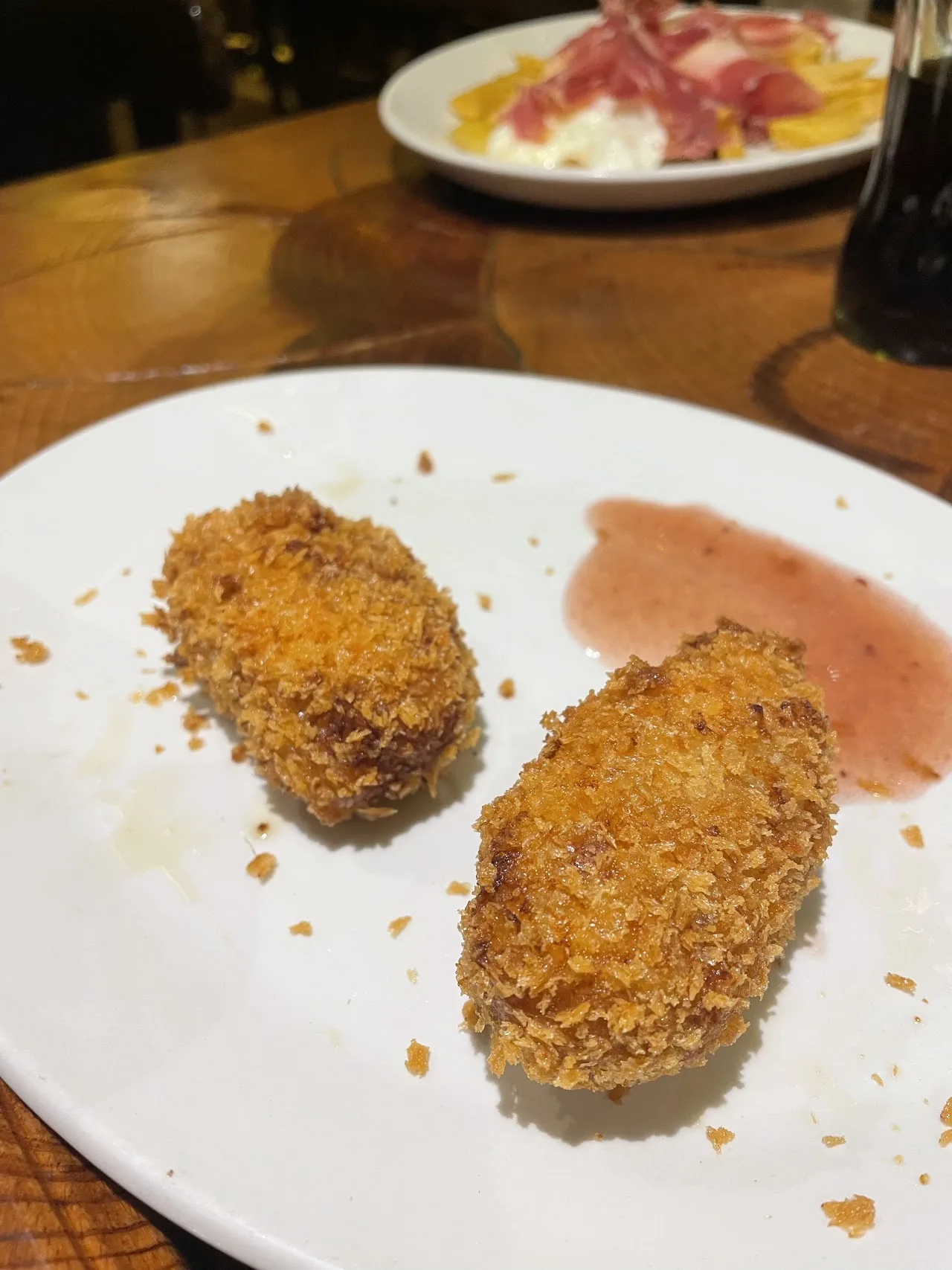 Two breaded croquettes on a plate