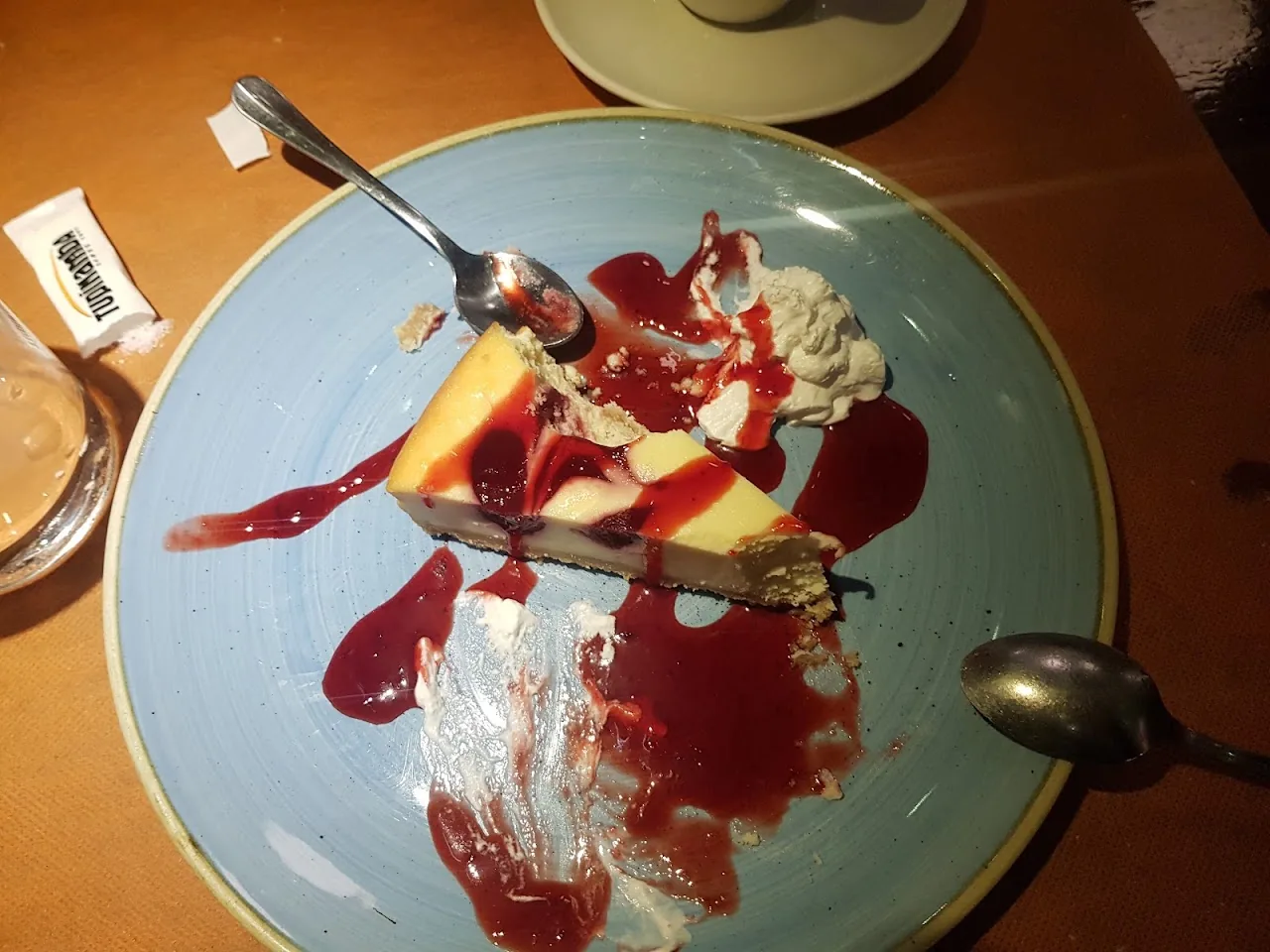 A slice of cheesecake with berry sauce