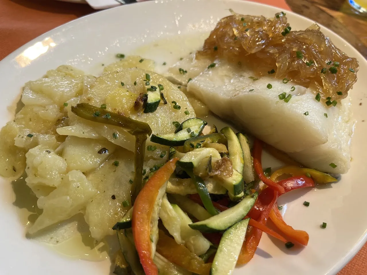 A fish fillet with sautéed vegetables and a citrus glaze