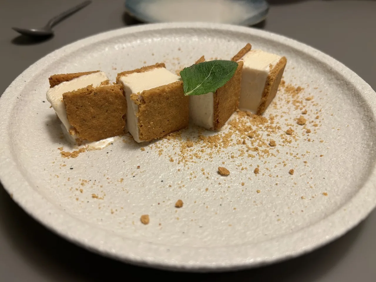 Three rectangular pieces topped with a basil leaf on a speckled plate
