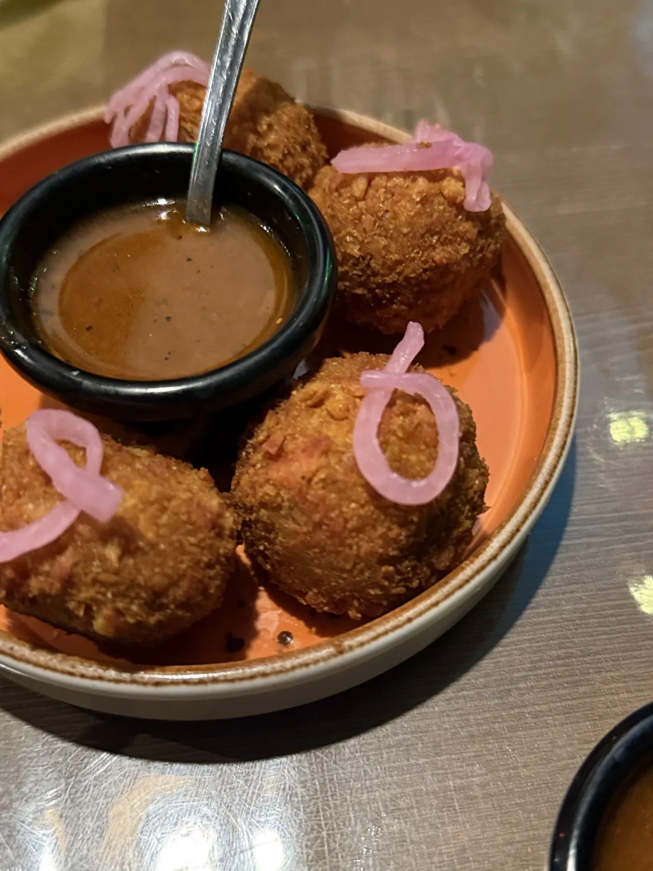 Round fried croquettes served with a dipping sauce