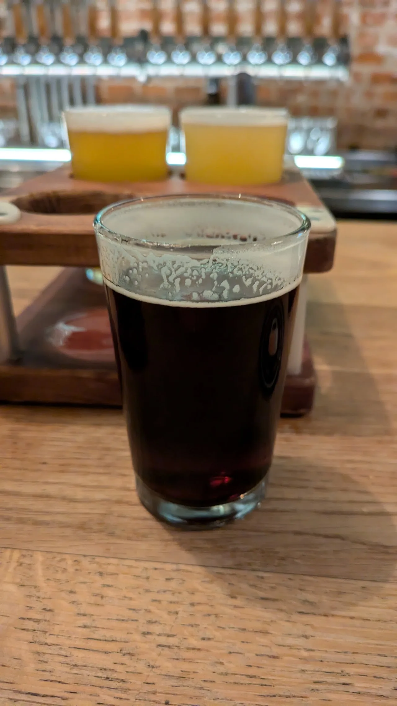 A flight of two beers, one pale and one dark, in glasses