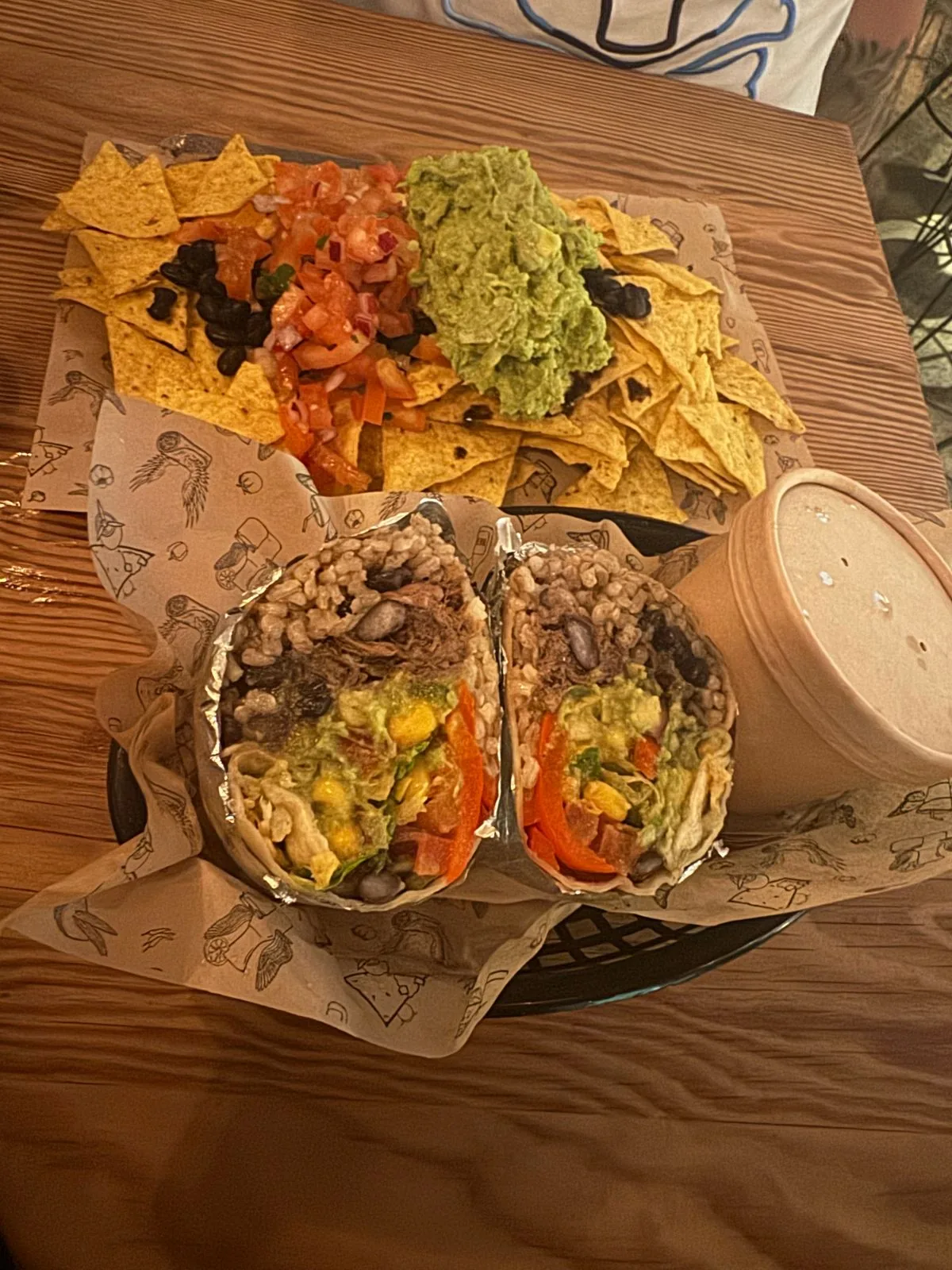 A platter of nachos and tacos with guacamole
