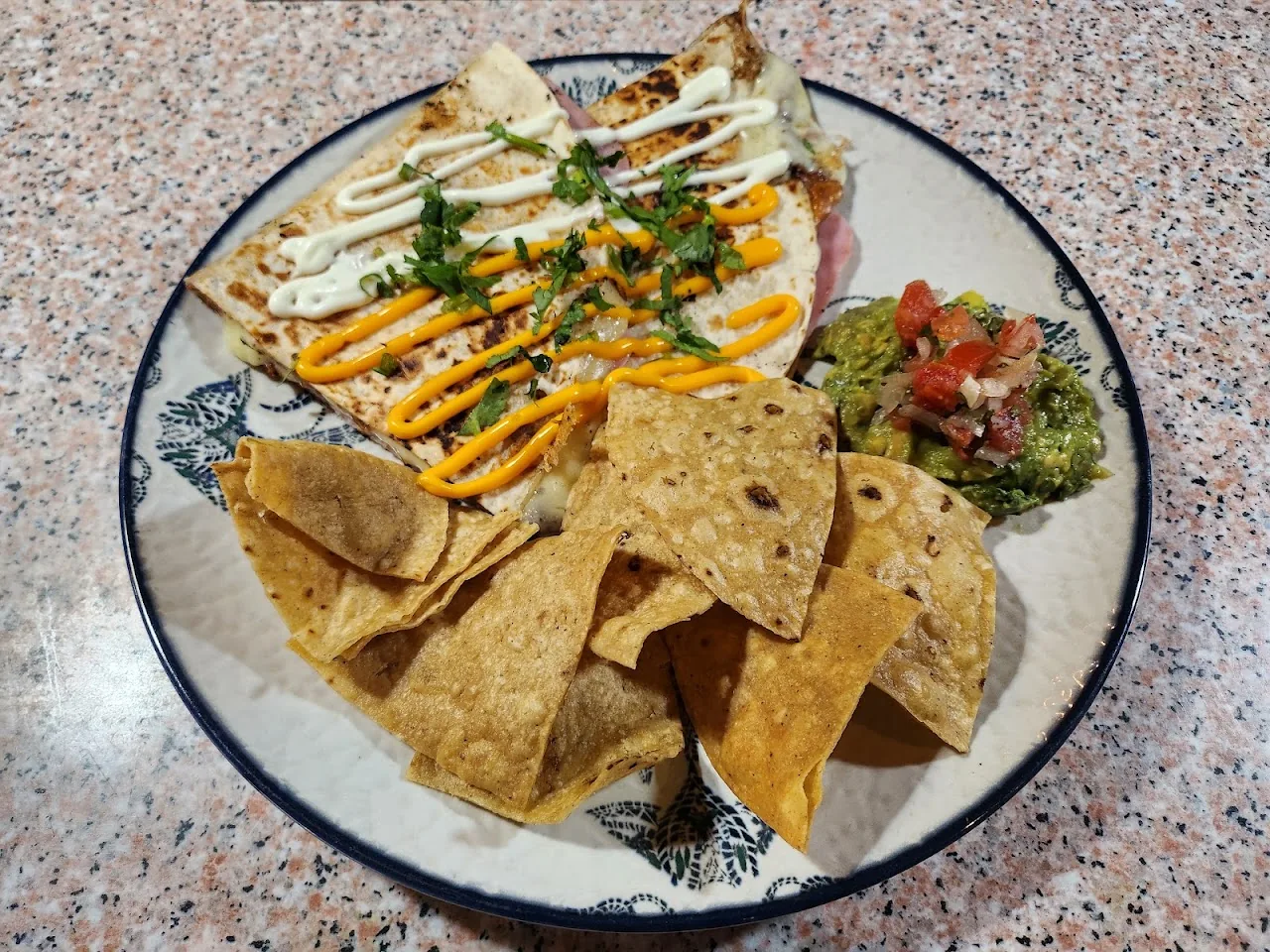 A quesadilla plate with tortilla chips, salsa, and guacamole