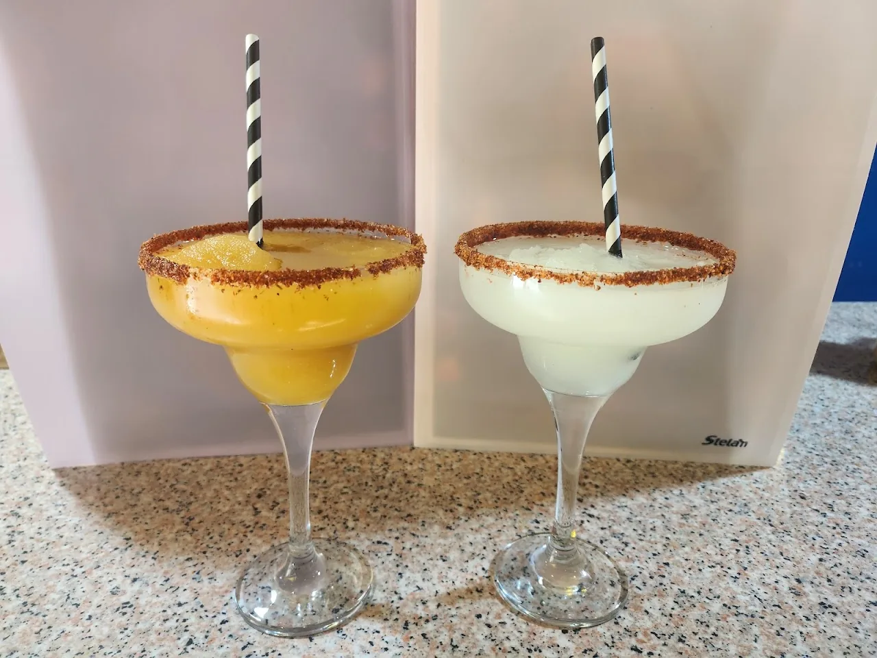 Two margaritas, one mango and one classic, in cocktail glasses