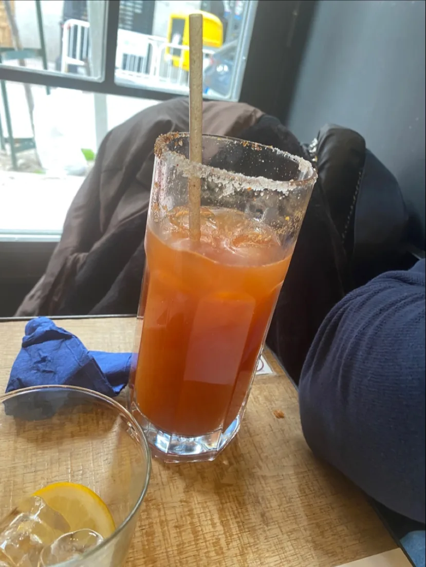 A tall glass cocktail with a citrus garnish
