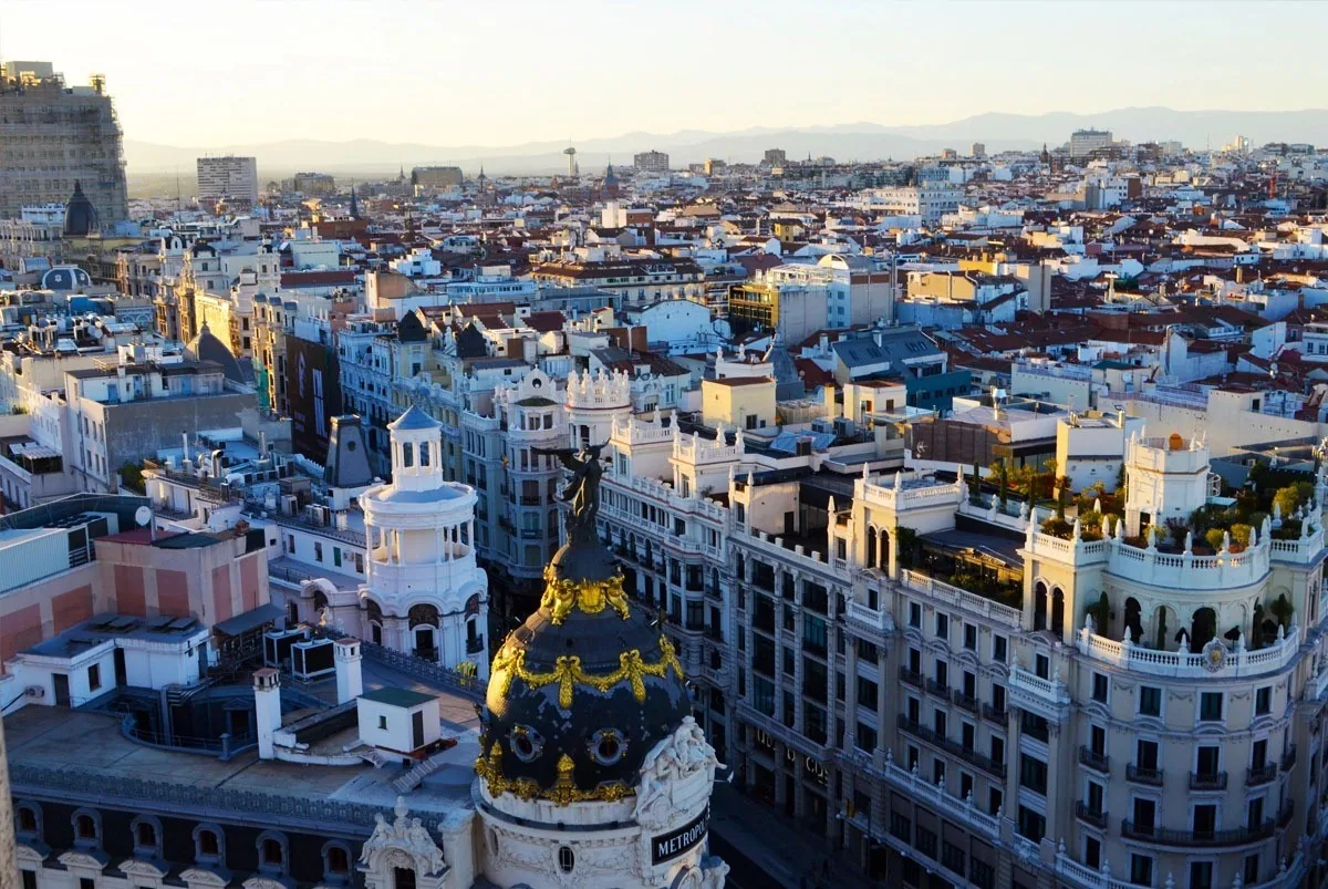 An aerial view over Madrid rooftops and a domed building from a high terrace