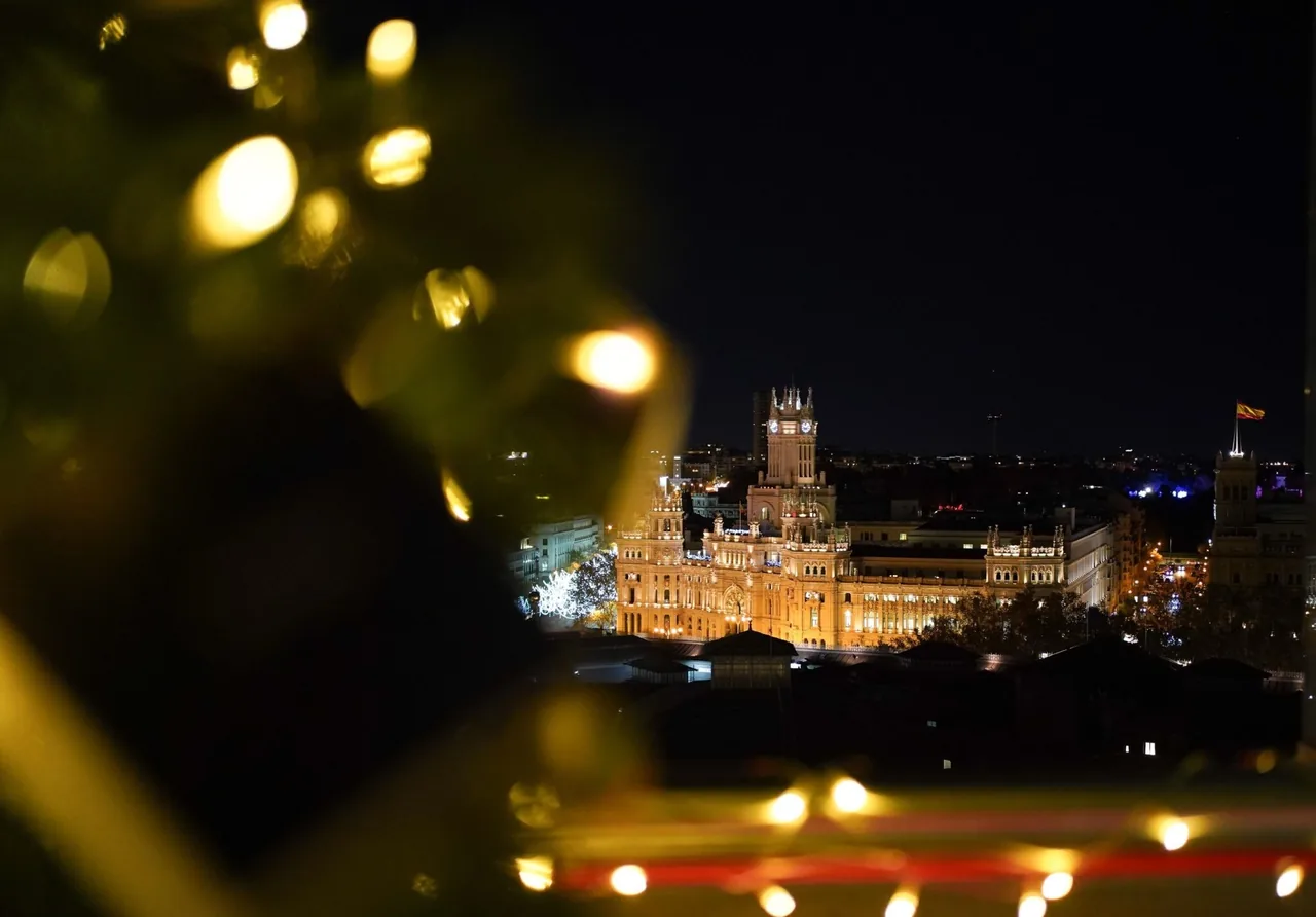 A night view of a lit domed building in Madrid seen past blurred foreground lights