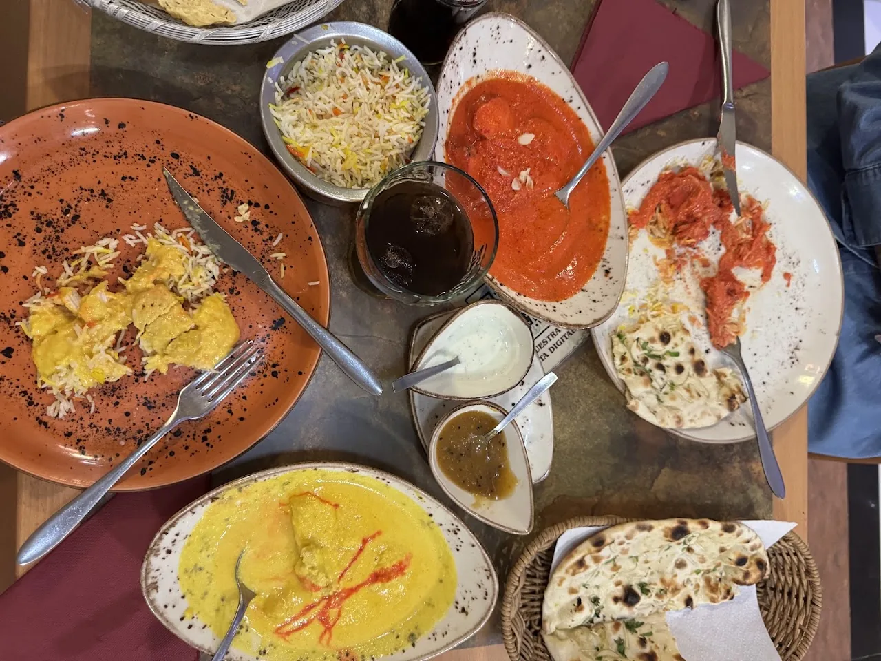 An assortment of curry dishes, rice, and naan bread