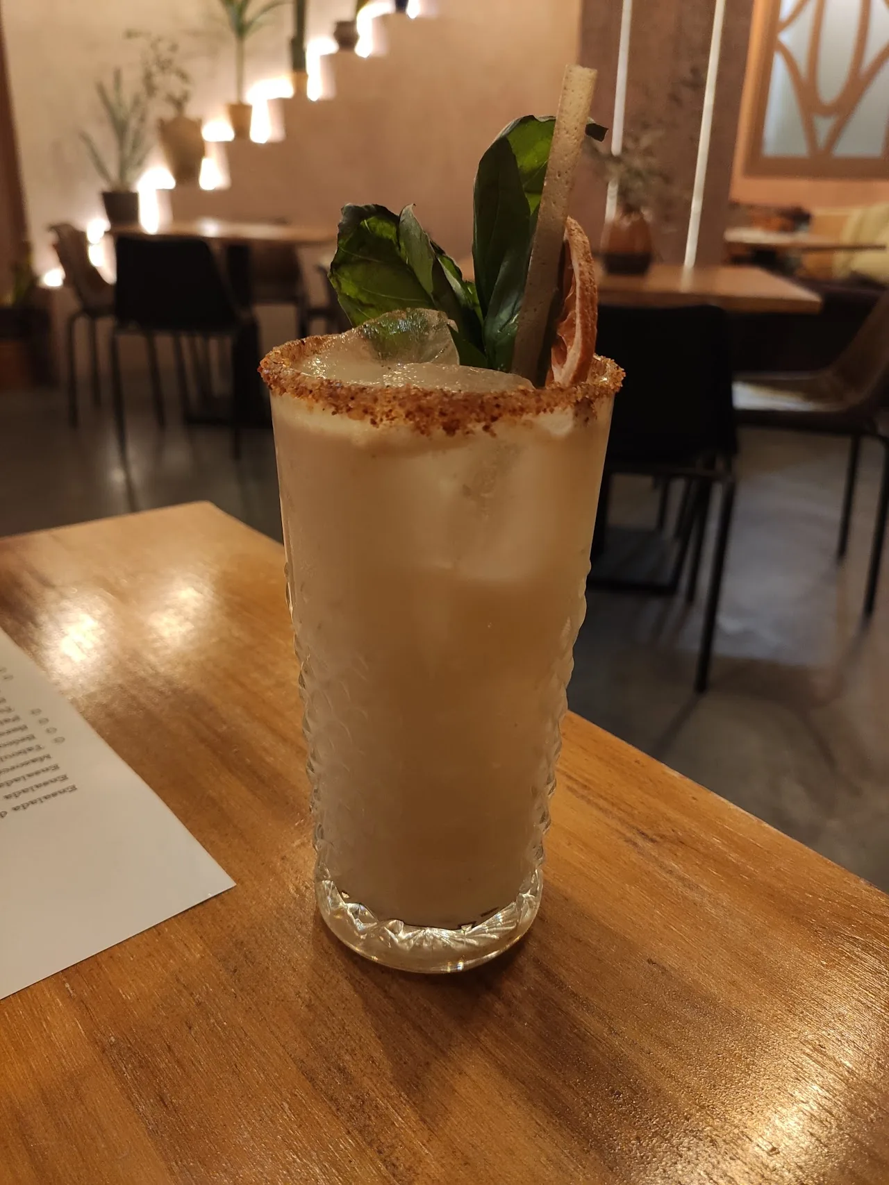 A cocktail garnished with mint in a rocks glass