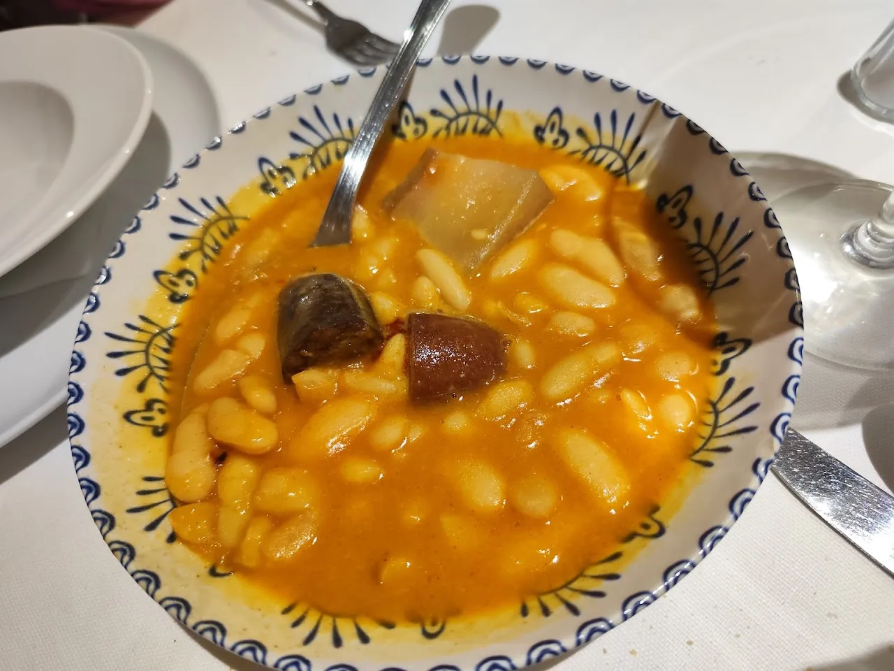 A bowl of white bean stew (fabada) with chorizo and morcilla