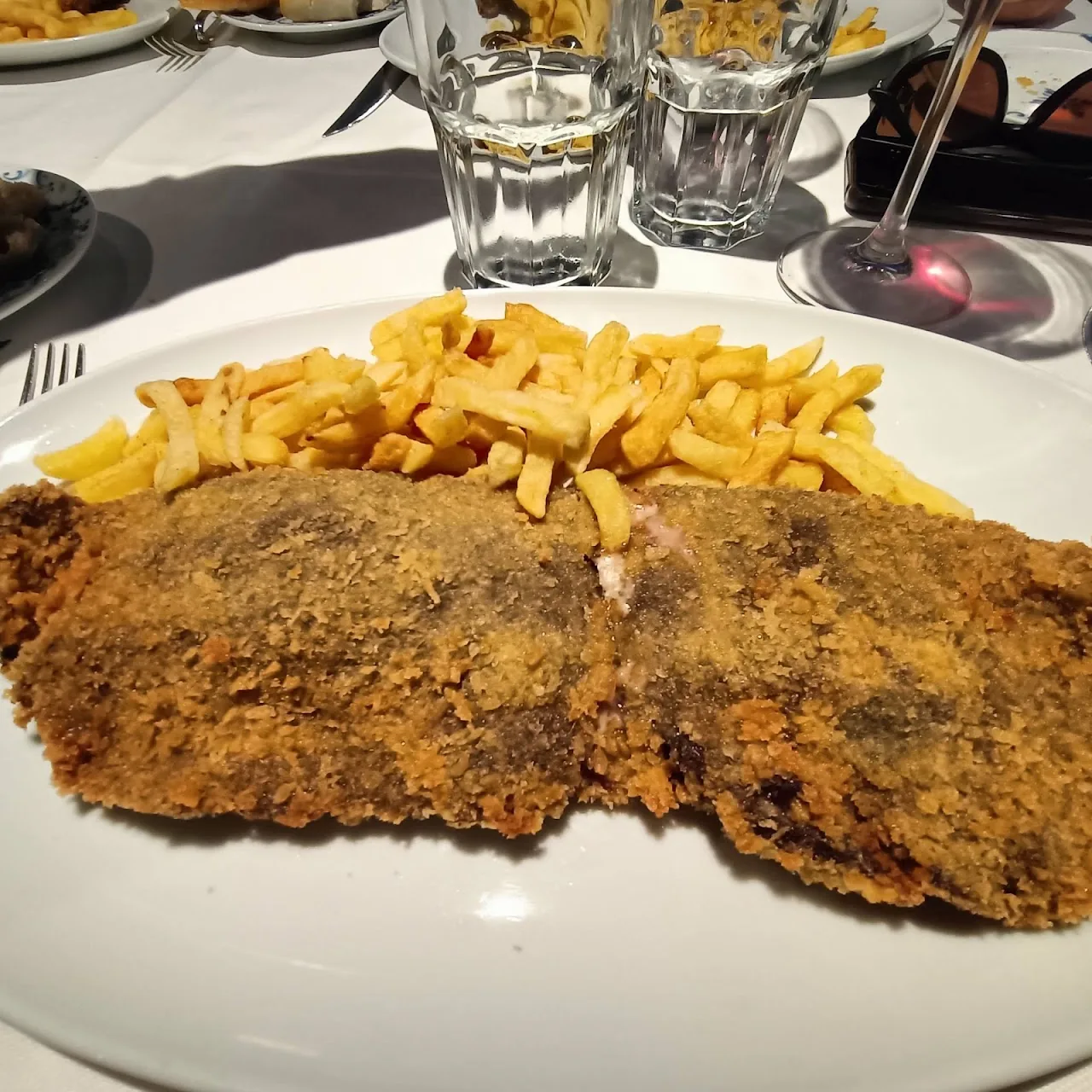 A breaded cutlet with a side of french fries