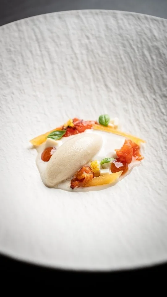 A bun filled with vegetables and sauce on a white plate