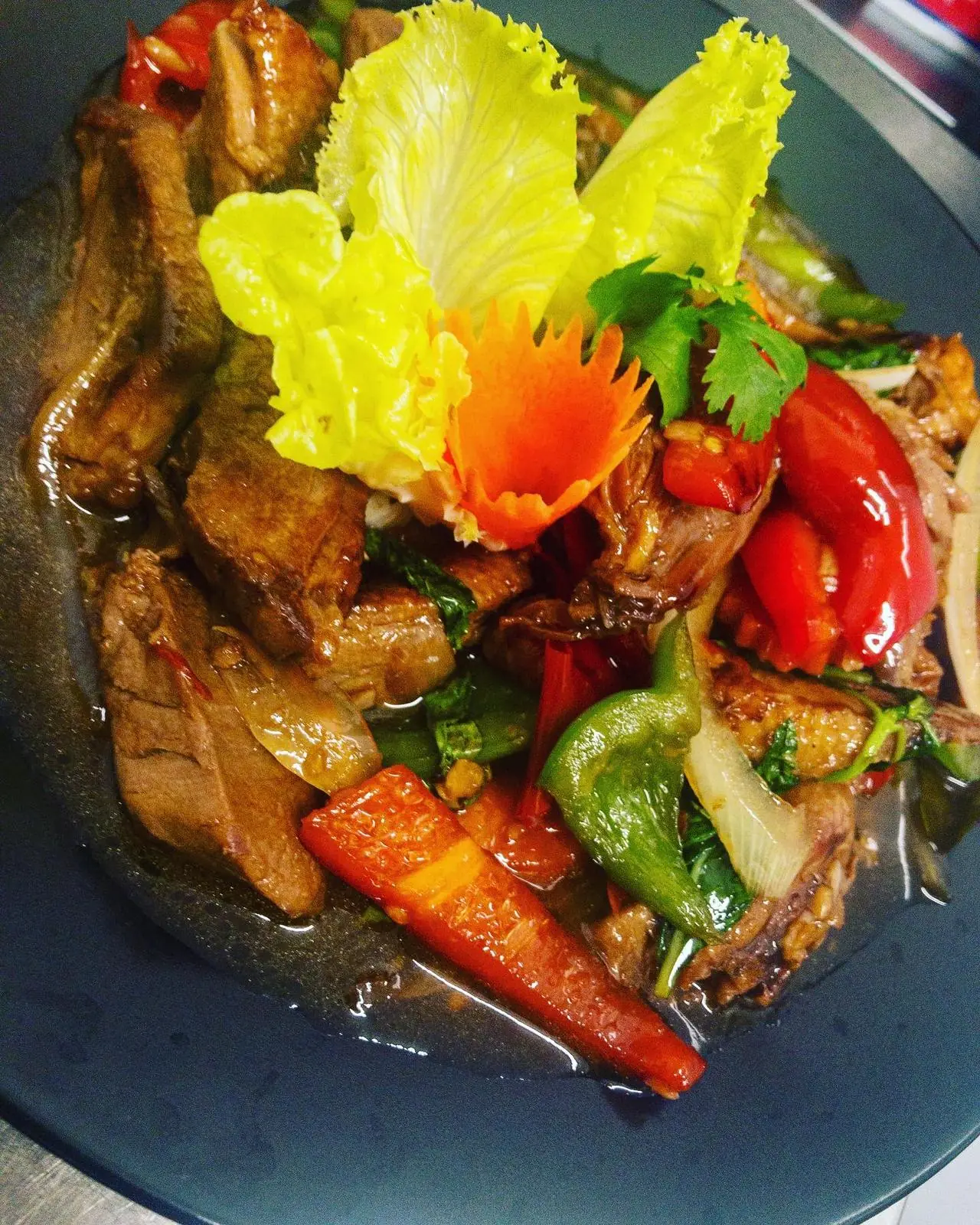 Stir-fried duck with basil, chili, tomato, and vegetables in sauce at Restaurant Thai Rico