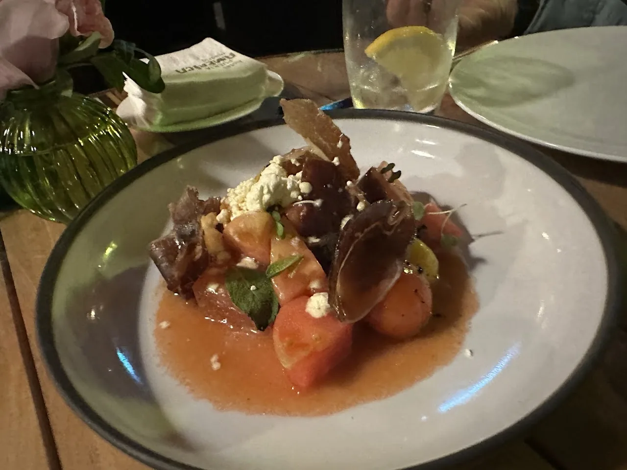 A seafood dish in an orange sauce with citrus and herbs