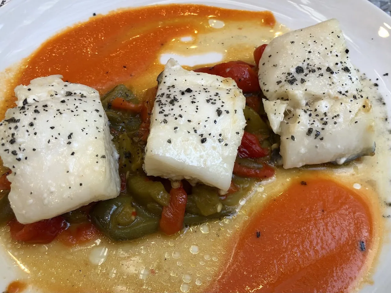 Pieces of white fish in a red pepper and tomato sauce