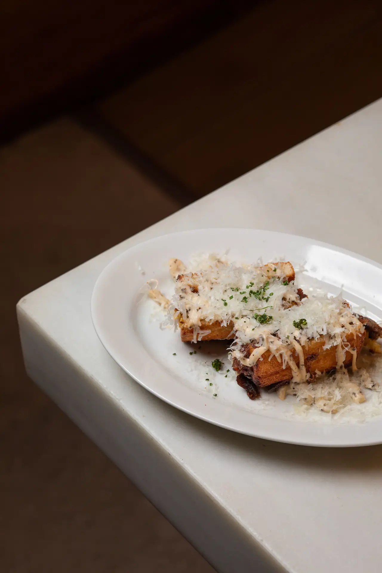 Crispy croquette-style dish topped with grated cheese and chopped herbs on a white plate, Tierra Brava