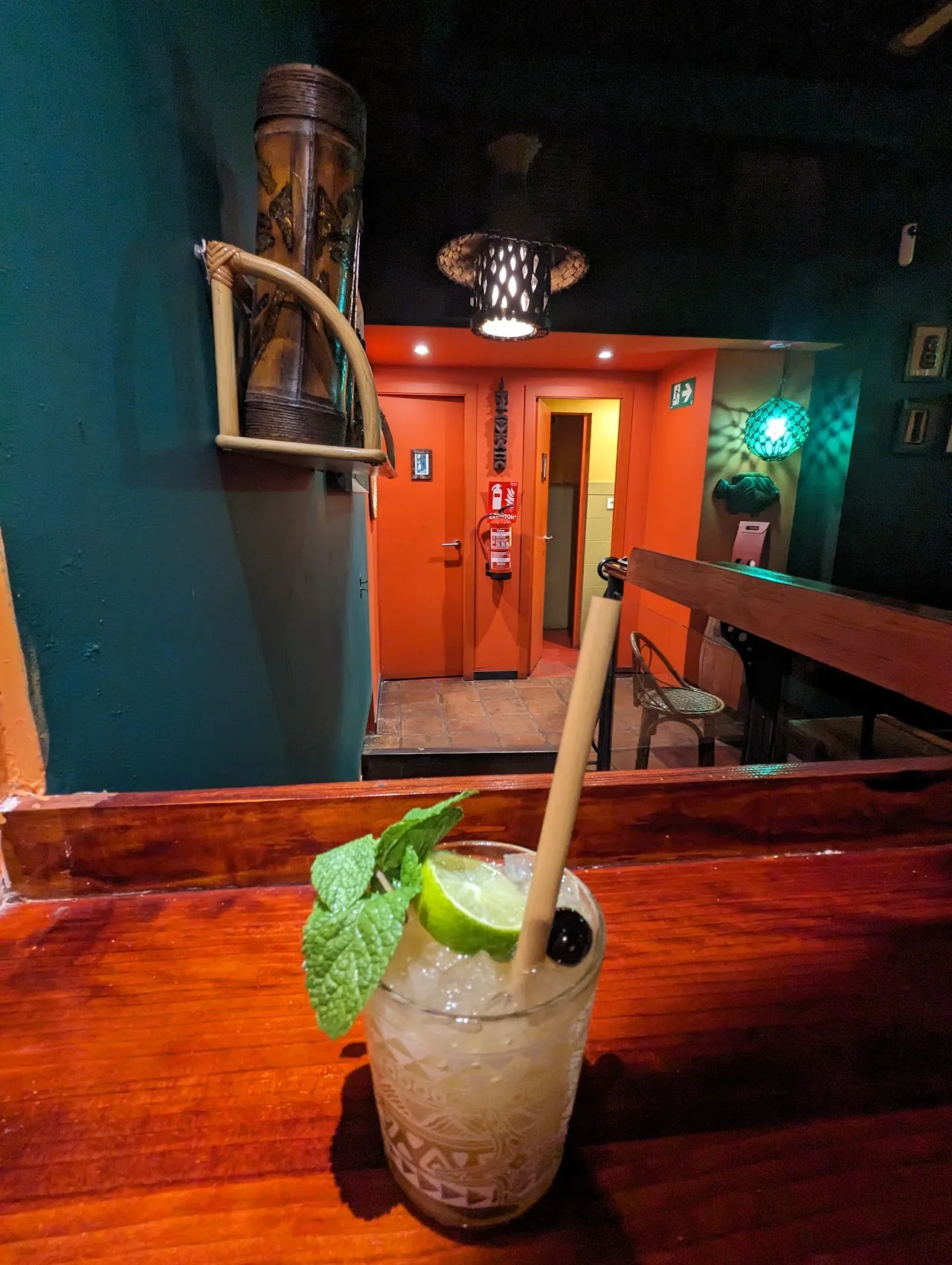 A tiki mug cocktail garnished with mint leaves