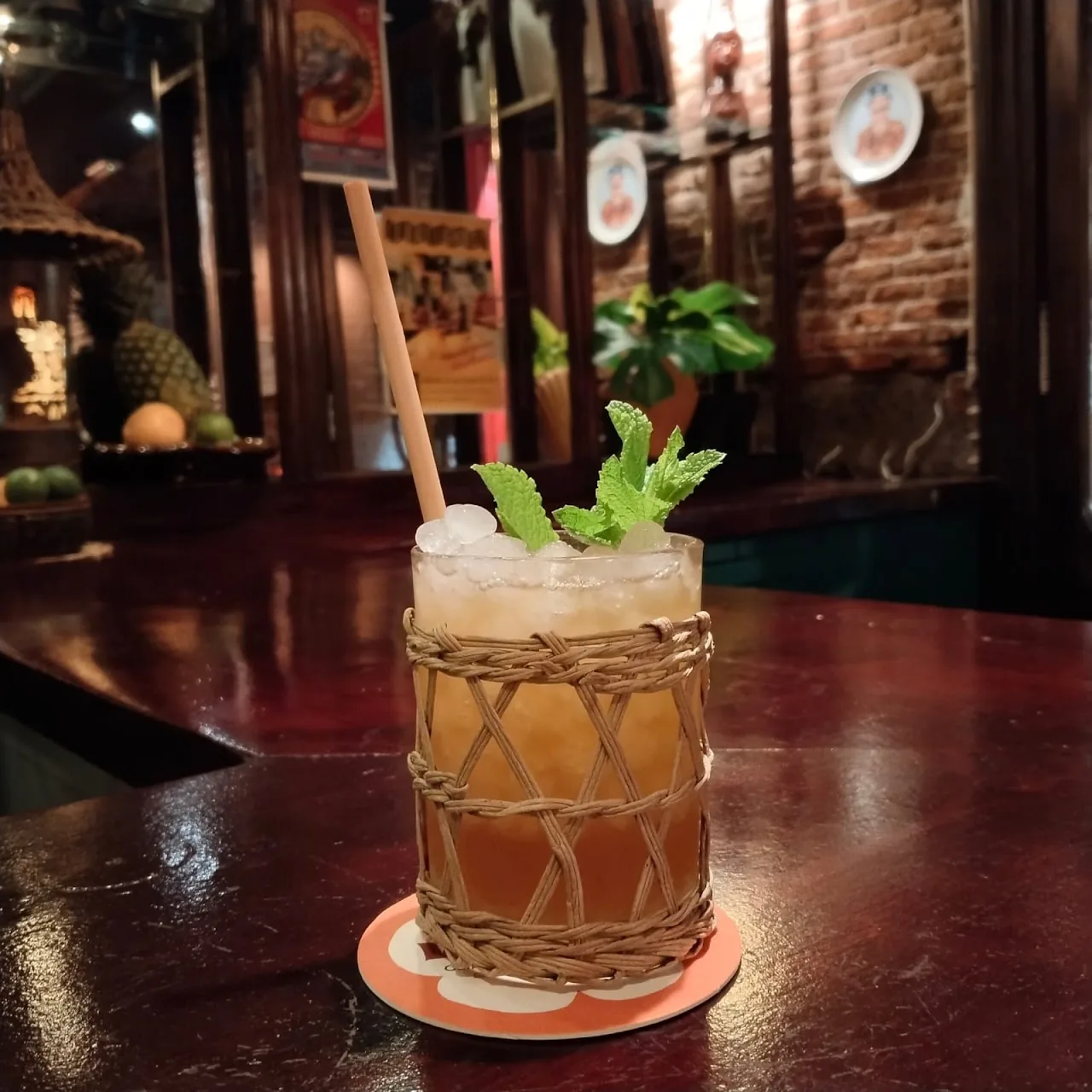 A tiki mug cocktail wrapped in rope, garnished with mint
