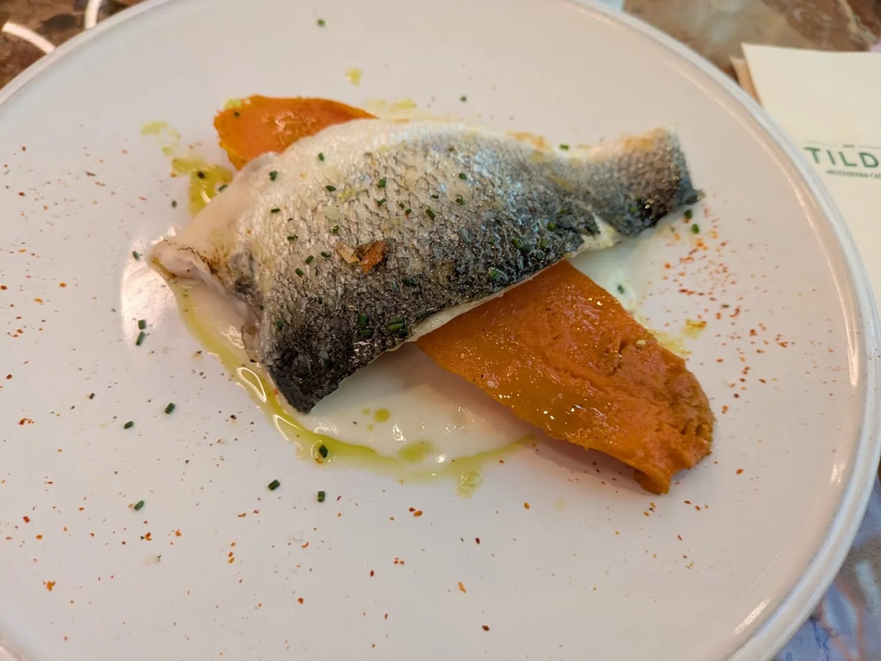 A fish fillet with orange puree and citrus segments
