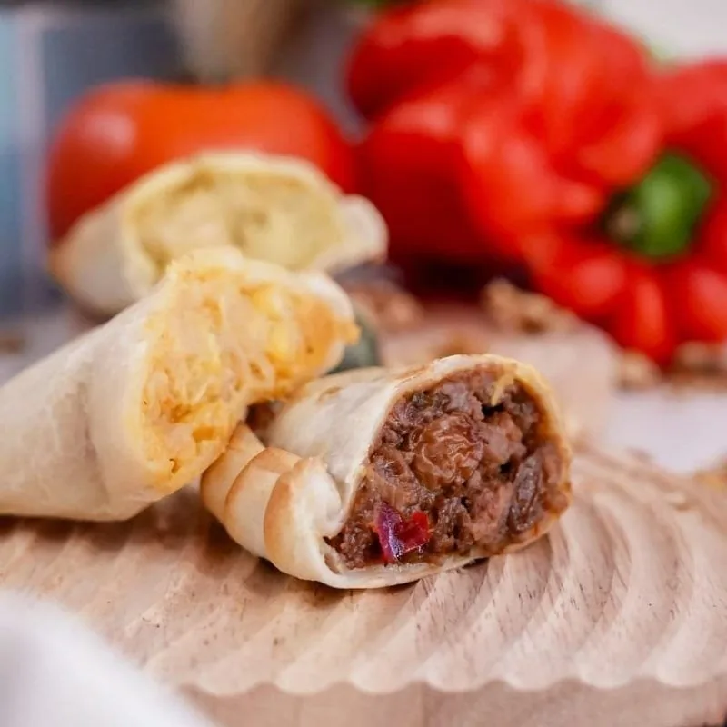 An empanada cut open to show a shredded meat filling