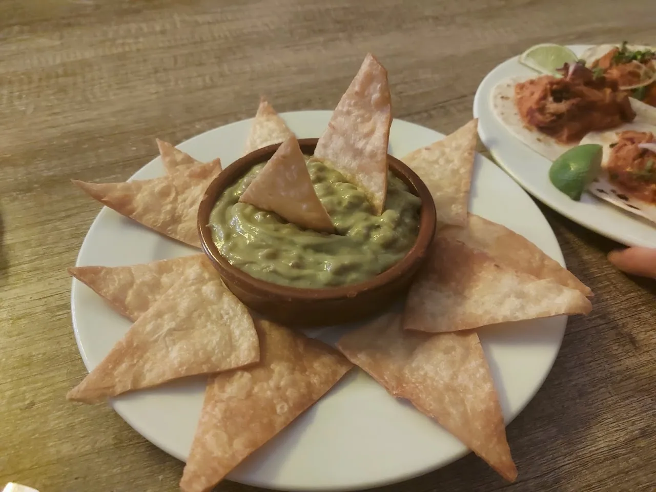 A bowl of guacamole surrounded by tortilla chips