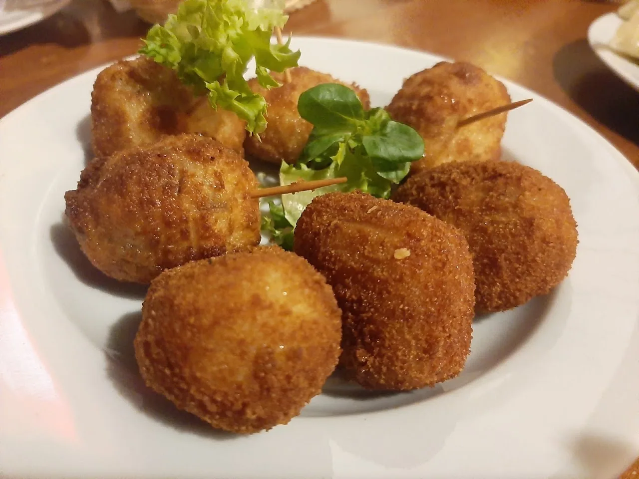 Breaded croquettes on a plate with fresh greens