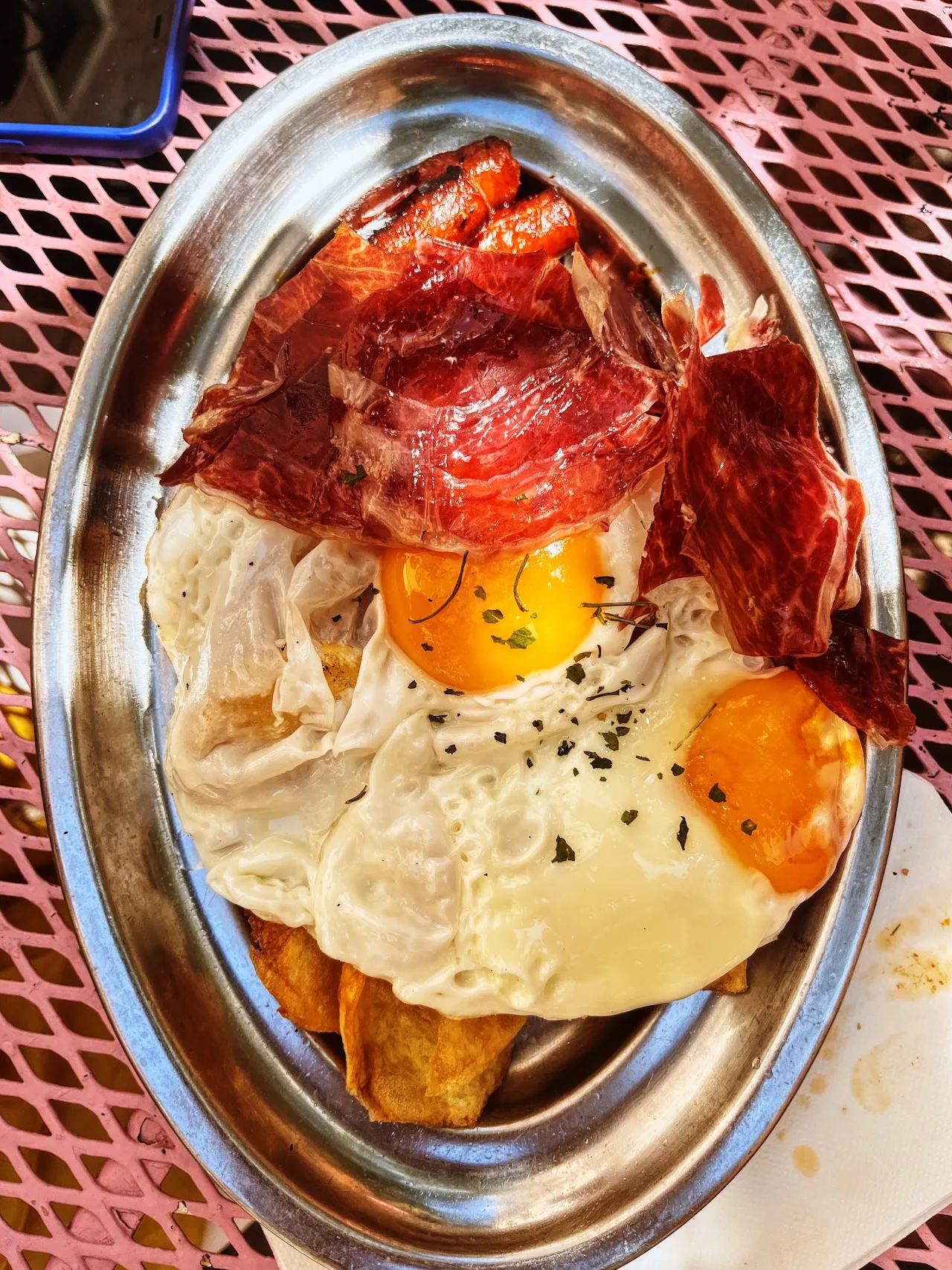 A mixed plate of cured ham, croquettes, and fried eggs with potatoes
