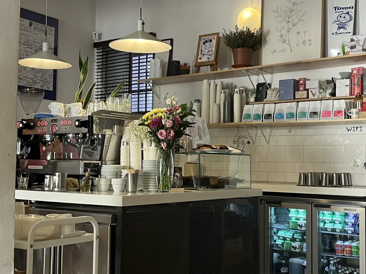 Café counter with an espresso machine and shelves of coffee bags.