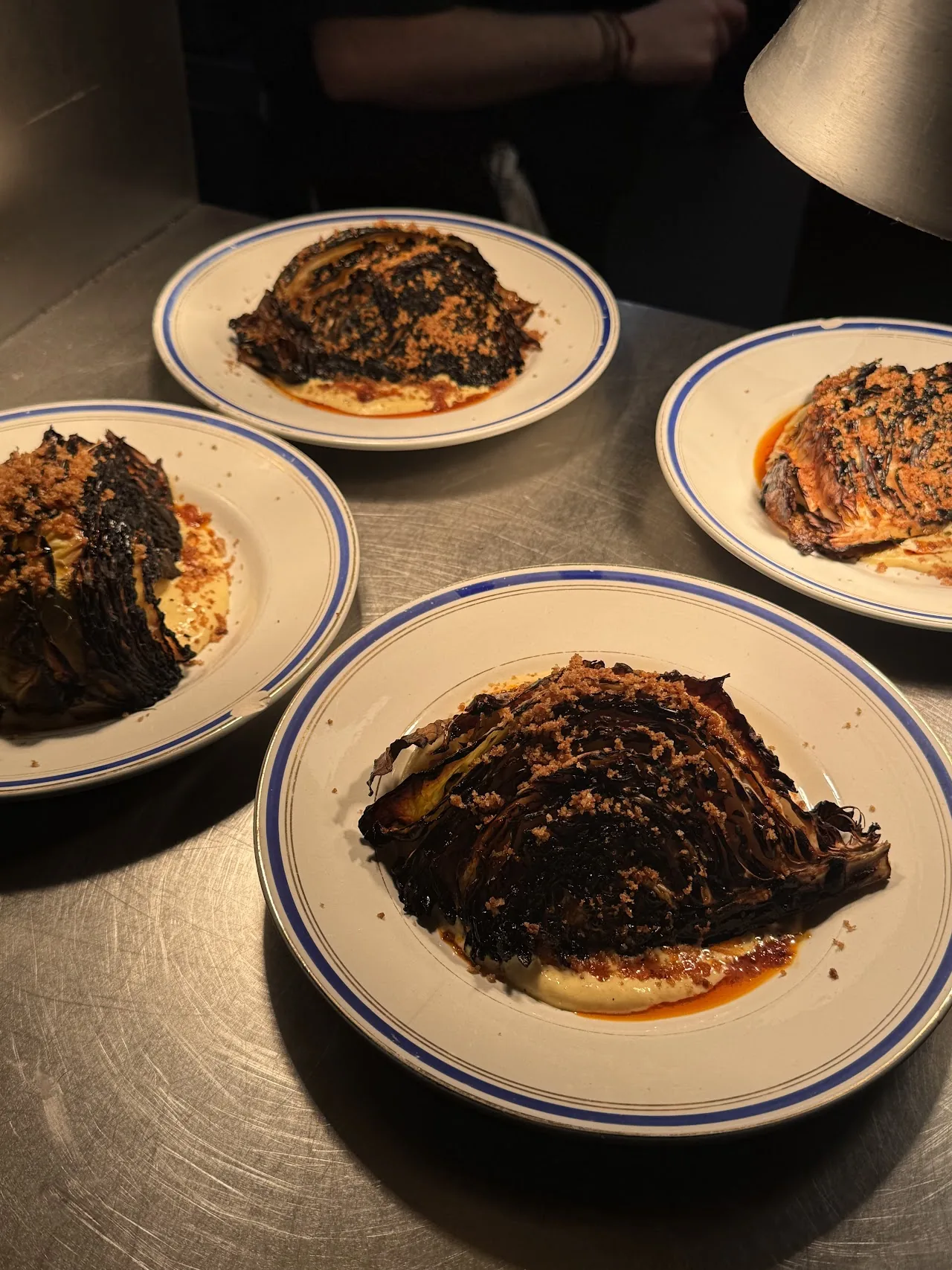 Three plates of a dark braised dish with a glossy sauce