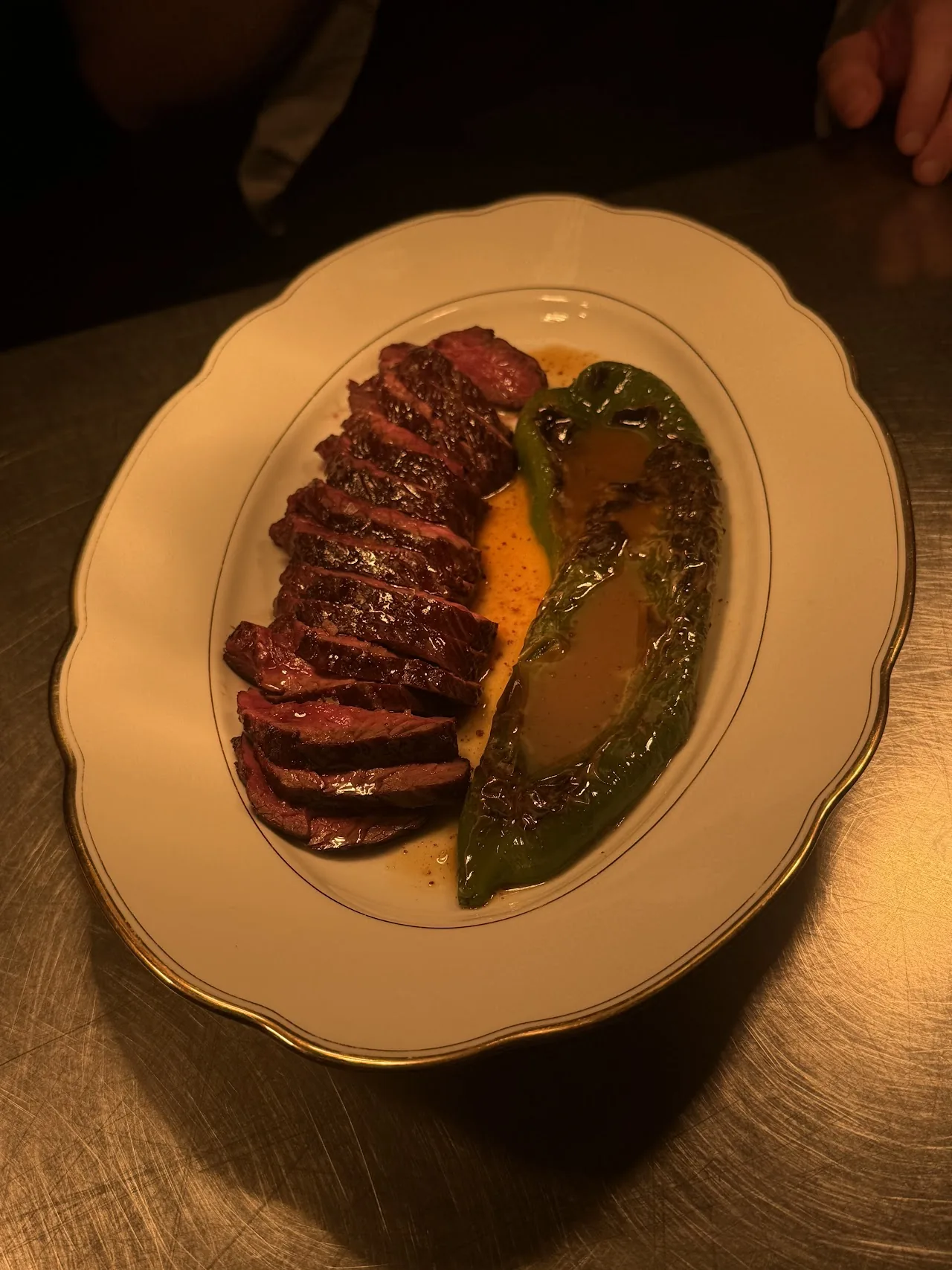Sliced duck breast fanned beside a green herb sauce