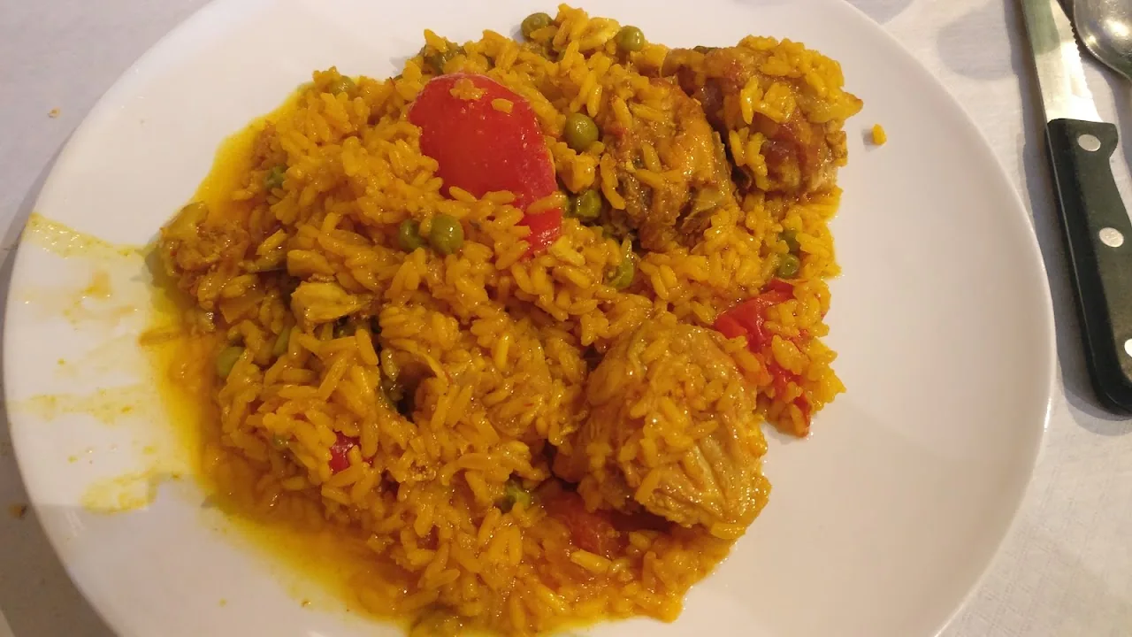 A plate of yellow rice with chorizo and peppers