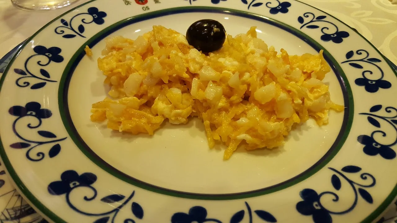 Shredded scrambled eggs with salt cod (bacalao dorado) on a decorative plate