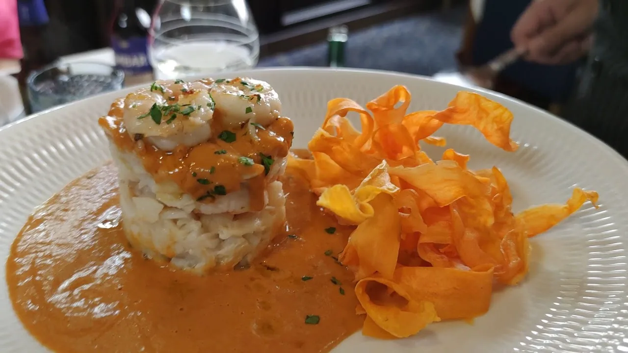 Shrimp with rice and carrot ribbons on a white plate