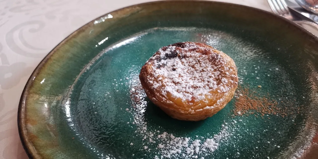 A small custard tart dusted with powdered sugar