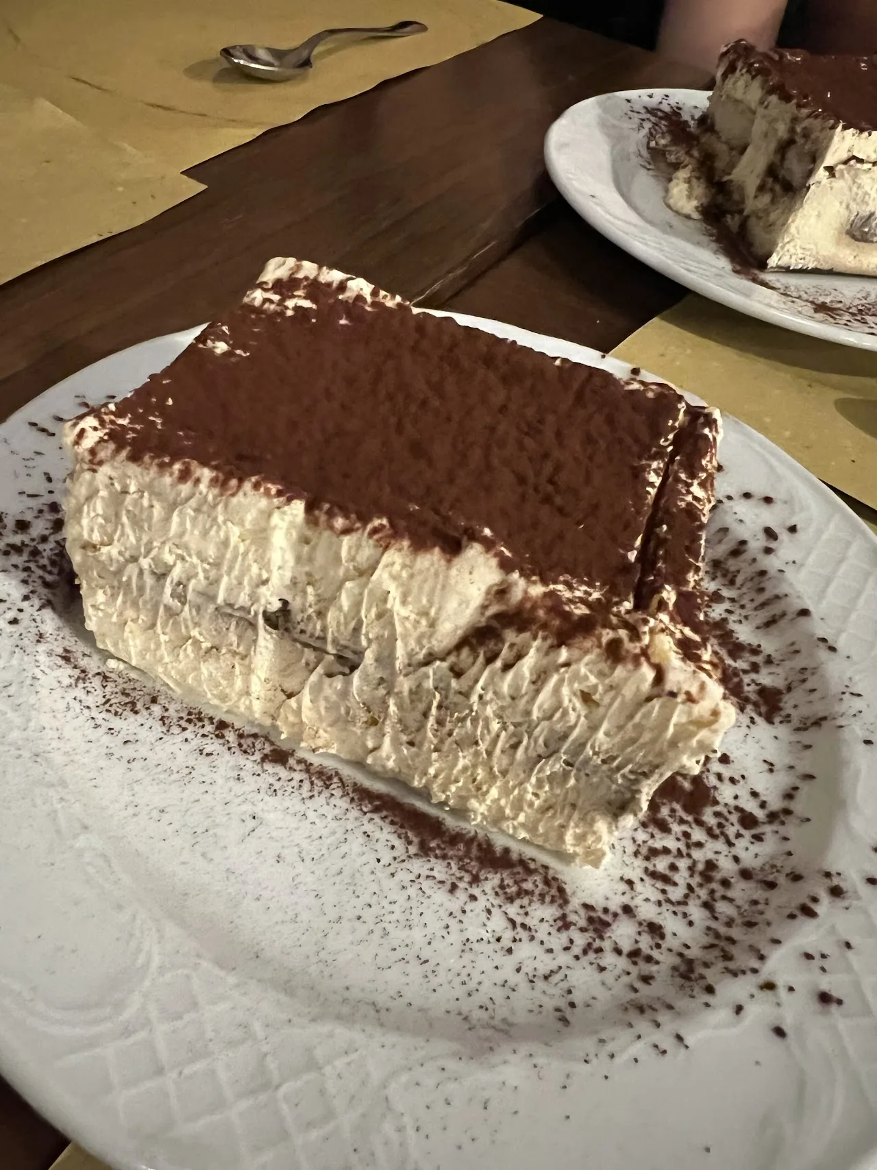 A slice of tiramisu dusted with cocoa powder