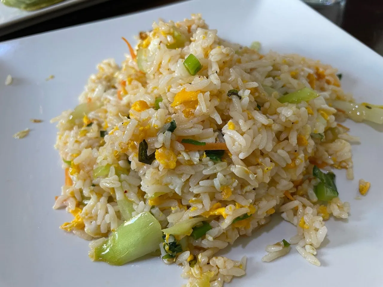 A plate of fried rice with mixed vegetables