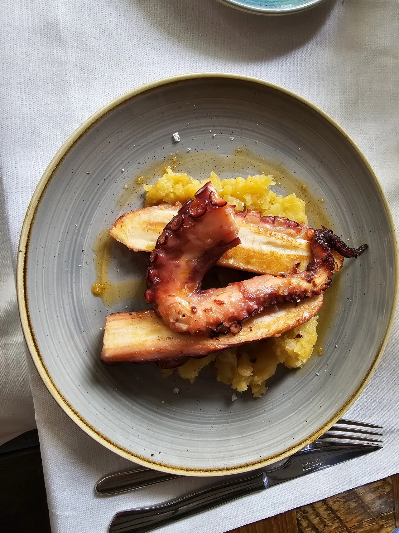 Grilled octopus slices over a yellow puree